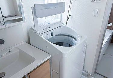 マンションの洗濯パンに設置された縦型洗濯機のイメージ